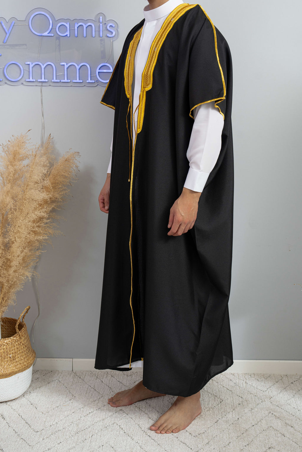 Homme arabe qui porte un Bisht saoudien noir avec un qamis blanc