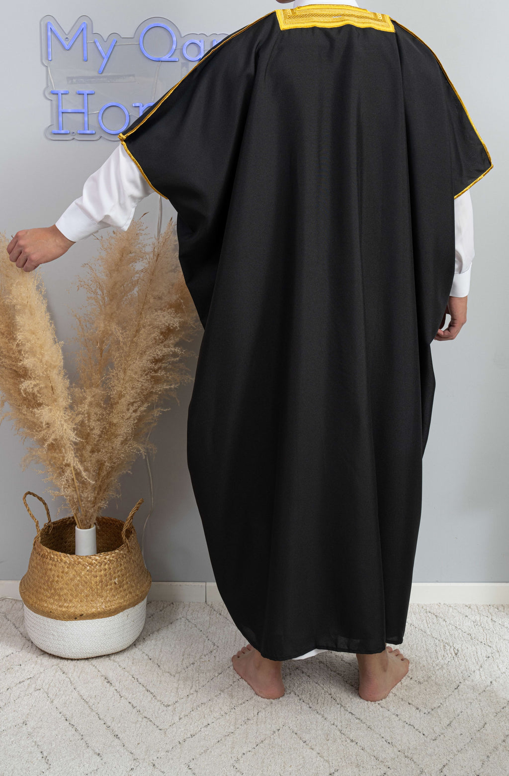 Homme arabe qui porte un Bisht saoudien noir avec liseré doré